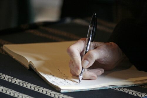 Eine Hand, die einen Stift über einem Dokument hält