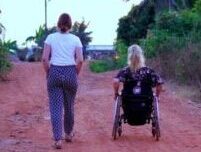 Eine Fußgängerin und eine Rollstuhlfahrerin sind gemeinsam unterwegs